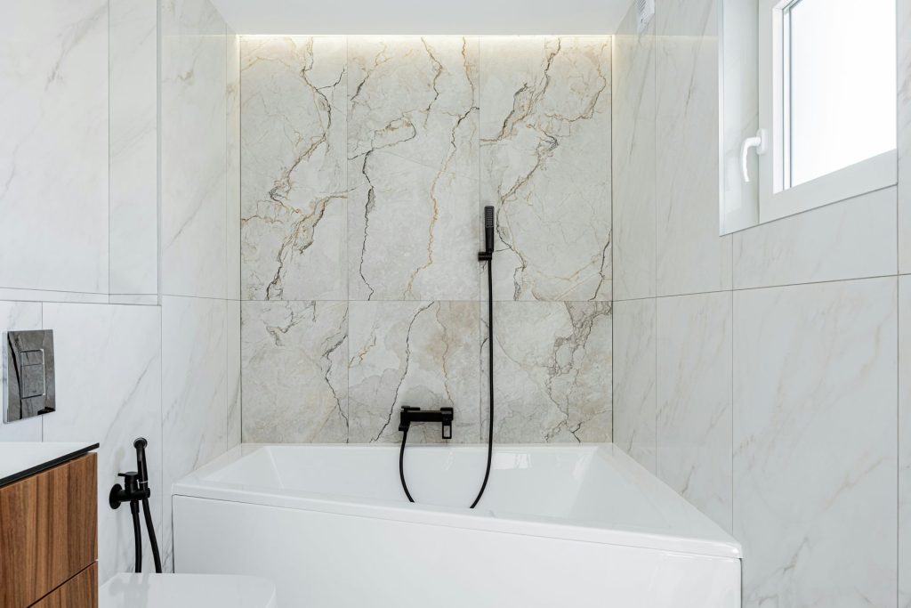 Salle de bains moderne avec marbre blanc et baignoire.